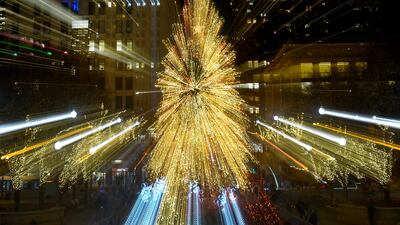 Tourists walk past the Millennium Park Christmas tree in Chicago. AP Photo