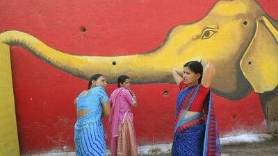 Hindu women comb their hair in front of a mural after taking a holy dip in the Shipra river during Simhastha Kumbh Mela in Ujjain, India. Jitendra Prakash / Reuters