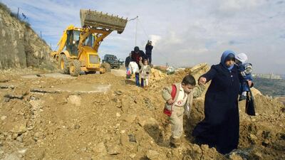 Palestinians walk along a demolished road by Israel leading to the village of Al Walaja in the West Bank. Musa Al Shaer / AFP