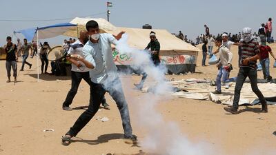 A demonstrator uses a tennis racket to hit back a tear gas canister fired by Israeli soldiers. Ibraheem Abu Mustafa / Reuter