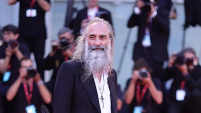 Screenwriter Warren Ellis, in a black suit with open white shirt. Getty Images