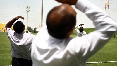 Three men look up during the UAE student flying competition. Students gather to design, build and fly their model planes. Delores Johnson / The National