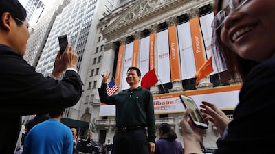 A Chinese tourist poses for a photograph in front of the New York Stock Exchange on the day of Alibaba’s initial public offering. Jason DeCrow / AP Photo