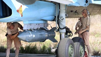 Russian military support crew attach a satellite guided bomb to jet fighter in Syria. Alexander Kots / AP