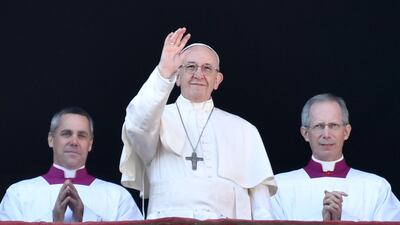 Pope Francis waves from the balcony of St Peter's basilica during the traditional "Urbi et Orbi" Christmas address and blessing given to the city of Rome and to the World. AFP PHOTO / Andreas SOLARO