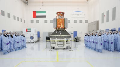 Engineers pose for a photograph with a model of KhalifaSat - the first satellite built entirely by Emirati engineers. The satellite was named after Sheikh Khalifa bin Zayed, Late President of the UAE. Wam