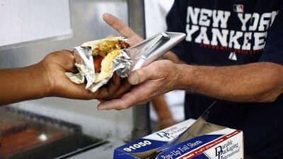 A fan buys a hot dog outside Yankee Stadium in New York, a city that aims to reduce widespread obesity through food regulation.