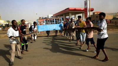 Sudanese protesters erect a barricade on a street. Reuters
