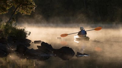 A kayaker paddles through morning mist on Pigeon Lake in Kawartha Lakes in central Ontario. The Canadian Press via AP