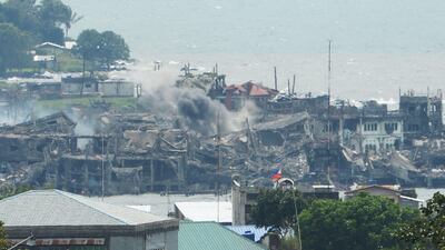 Black smoke billows from destroyed buildings after artillery fire from government troops hits the remaining militant postion near the lake in Marawi, on the southern island of Mindanao. Ted Aljibe / AFP