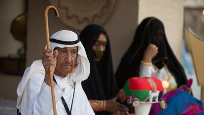 A man sits with women doing traditional tell. Silvia Razgova / Crown Prince Court — Abu Dhabi