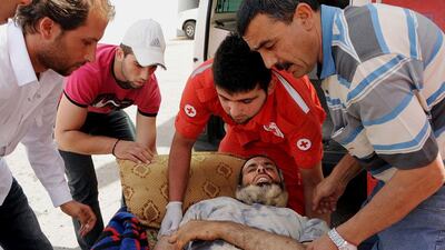 Members of the Lebanese Red Cross carry a Syrian man who was wounded in a clash between the rebels and Syrian government forces in the Bekaa Valley, east of Beirut, Lebanon. AP Photo