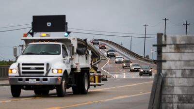 A line of cars exit Port Aransas, Texas, toward the surge wall on TX-361 in as Hurricane Harvey approaches. Nick Wagner /Austin American-Statesman via AP