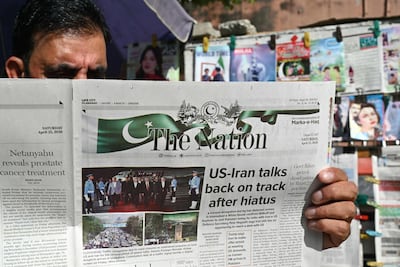 A man reads a newspaper at a roadside stall in Islamabad on April 25. AFP