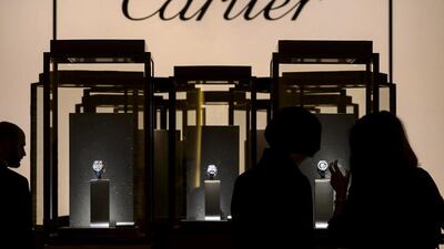 Visitors look at items on display at the stand of Cartier. Fabrice Coffrini / AFP