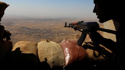 Iraqi Kurdish Peshmerga fighters hold a position about 25km east of Mosul. Safin Hamed / AFP