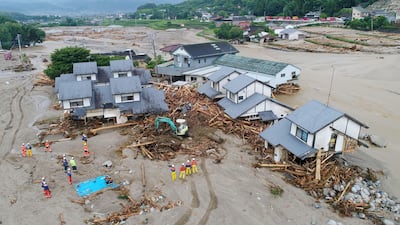 Firefighters inspect the collapsed houses in the mud following the flooding caused by heavy rain in Asakura, Fukuoka prefecture, southwestern Japan, Saturday, July 8, 2017. The southern island of Kyushu suffered heavy rain after Typhoon Nanmadol swept across Japan earlier in the week, dumping large amounts of rain that damaged homes, roads and rice fields. (Koji Harada/Kyodo News via AP)