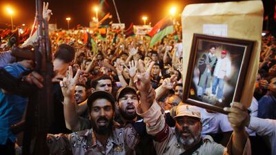 People celebrate the capture in Tripoli of Moammar Gadhafi's son and one-time heir apparent, Seif al-Islam, at the rebel-held town of Benghazi, Libya, early Monday, Aug. 22, 2011. Libyan rebels raced into Tripoli Sunday and met little resistance as Gadhaf???