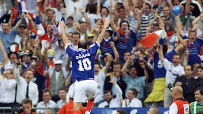 Frenchman Zinedine Zidane jumps over the barrier as he celebrates after scoring the first goal for his team on July 12, 1998 at the Stade de France in Paris, during the 1998 World Cup final match between Brazil and France. Patrick Hertzog / AFP