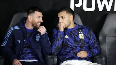 Argentina forward Lionel Messi teammate Leandro Paredes speak on the bench. AFP
