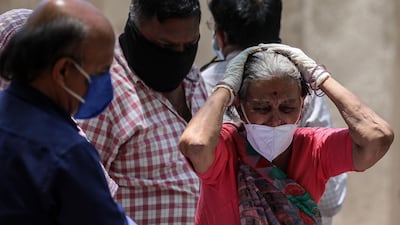 People mourn while they perform the last rites for their relatives who died with Covid-19 during their funeral at a cremation ground in Ahmedabad, India. EPA