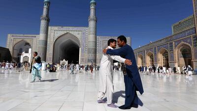 Afghan people greet each other after congregational prayers in Herat, Afghanistan. EPA