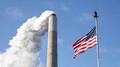Emissions rise from a smokestack alongside an US flag at a factory in Ohio. Employment numbers in the US manufacturing sector are about 720,000 lower than before pandemic-related shutdowns began in February. Bloomberg