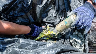 Dive volunteers with the collected bags of trash at Abu Dhabi Dhow Harbour. Victor Besa / The National