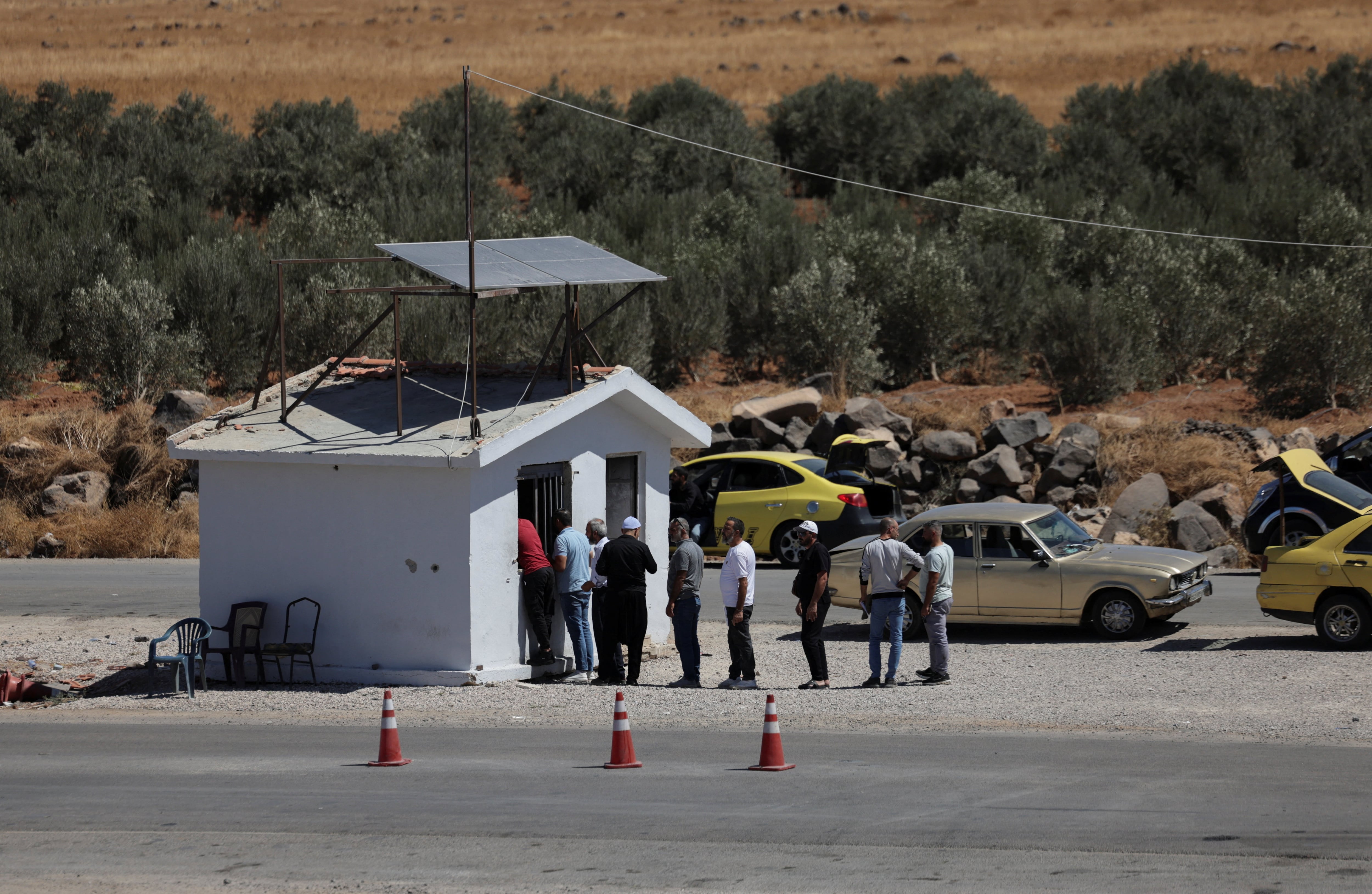A group of civilians at a checkpoint in Sawara Sughra, in Sweida province. Reuters