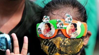 A Trinamool Congress party supporter wears glasses with pictures of party chief Mamata Banerjee after winning an absolute majority in the West Bengal state polls. EPA