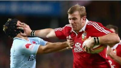 Tom Croft of the Lions fends off Tom Kingston.