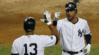 New York Yankees' Derek Jeter (right) is congratulated by teammate Alex Rodriguez after Jeter hit a solo home run against the Minnesota Twins.