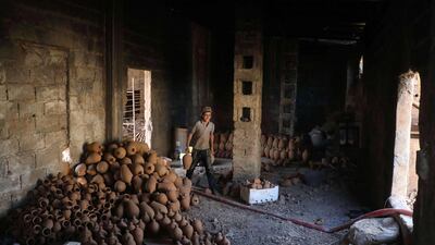 A potter arranges baked pots at a pottery in the Syrian town of Armanaz, 20 kms northwest of Idlib. AFP