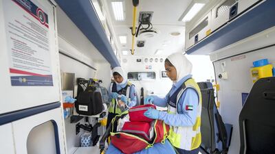 Marwa Alamoodi, L, and Maha Alfalasi, R, prepare an ambulance before it is dispatched. Ruel Pableo for The National