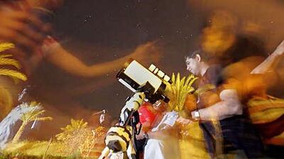 Spectators gather in the courtyard of the Bab Al Shams resort hotel in Dubai to see the annual Perseid meteor shower.