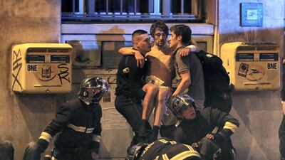 French fire brigade members aid an injured man near the Bataclan concert hall following a terror attack in Paris, on November 13, 2015. Christian Hartmann / Reuters