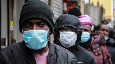 People wait for a distribution of masks and food from the Rev Al Sharpton in the Harlem neighborhood of New York, after a new state mandate was issued requiring residents to wear face coverings in public. AP