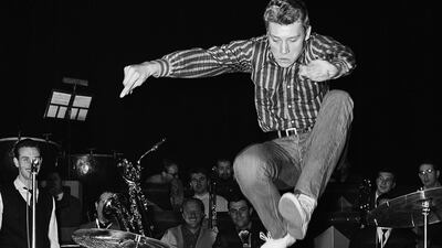 FILE - This Oct. 22 1962 shows French pop singer, Johnny Hallyday, leaps into the air whilst rehearsing at the Olympia Theater in Paris. The French president's office says Hallyday, who packed sports stadiums for decades, has died at age 74. (AP Photo/Jean Jacques Levy, File)