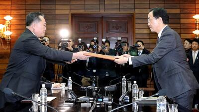 South Korean Unification Minister Cho Myoung-gyon exchanges documents with his North Korean counterpart Ri Son-gwon during their meeting at the truce village of Panmunjom, North Korea March 29, 2018. Korea Pool / Yonhap
