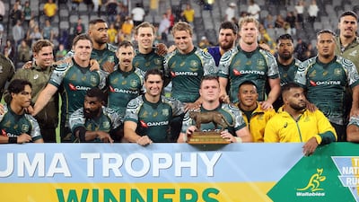 Australian players with the Puma trophy after the match. AFP