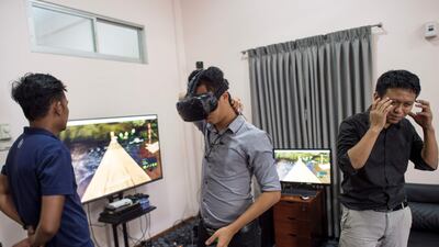 Nyi Lin Seck (Right) speaks about virtual reality technology to curious people wanting to learn more about it during a one day open house at his office in Yangon. Ye Aung Thu / AFP