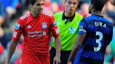 Andre Marriner, the referee, centre, steps in between Luis Suarez, and Patrice Evra during the match at Anfield last year.