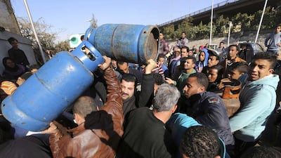People wait in line to buy gas cylinders at a distribution point in Cairo. Egypt is going through its worst energy crisis in decades and is seeking fresh sources of natural gas, which powers most of its homes and factories. Mohamed Abd El Ghany / Reuters
