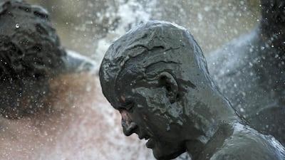 A participant gets a shower after a handball match at the “Wattoluempiade,” or Mud Olympics, in the northern German city of Brunsbuettel. Morris Mac Matzen / Reuters