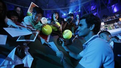 Roger Federer of Switzerland gives his autographs to fans during a fan meeting event ahead of the Shanghai Masters at Qizhon Tennis Center in Shanghai, China, Saturday, Oct. 5, 2013. AP Photo/Eugene Hoshiko