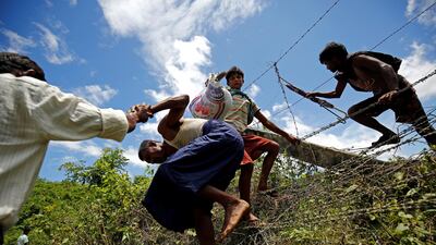 Rohingya people cross the border fence to enter inside Bangladesh border, in Cox’s Bazar, Bangladesh, August 27, 2017. Mohammad Ponir Hossain/Reuters