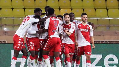 Monaco's Spanish midfielder Cesc Fabregas (C) celebrates with teammates after scoring from the penalty. AFP