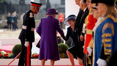 Britain's Queen Elizabeth II, centre, shakes hands with Britain's Prime Minister Theresa May, right, on the dias as they take their places for a ceremonial welcome for King Willem-Alexander and Queen Maxima of the Netherlands on Horse Guards Parade in London at the start of the Dutch King and Queen's two-day state visit. Matt Dunham / AFP