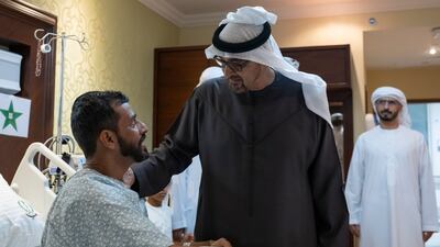 Sheikh Mohamed speaks with Capt Al Nuaimi at the military hospital