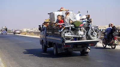 Syrian children riding in the back of a truc as families flee north from the countryside of of Hama and Idlib provinces. Muhammad Haj Kadour / AFP